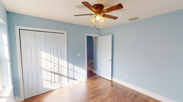 unfurnished bedroom featuring a textured ceiling, hardwood / wood-style flooring, and ceiling fan