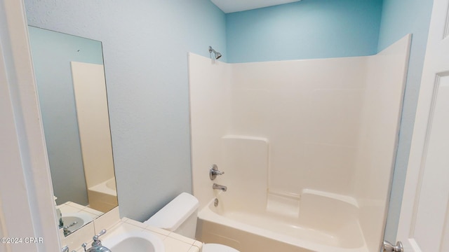 bathroom with shower / bath combination and toilet