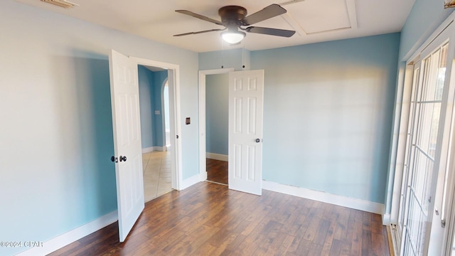 unfurnished bedroom featuring ceiling fan and dark wood-type flooring