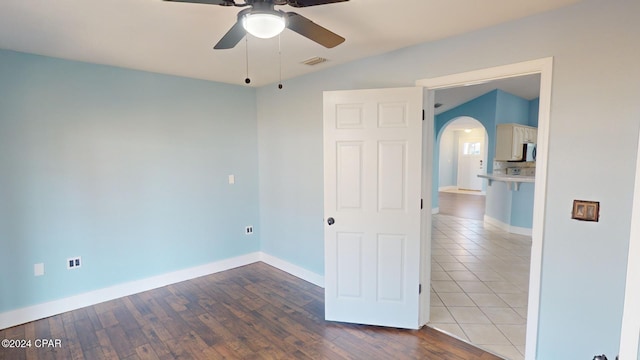 empty room with ceiling fan, wood-type flooring, and vaulted ceiling