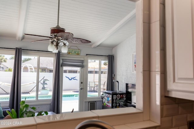 interior space with ceiling fan and beam ceiling