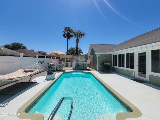 view of pool featuring a grill and a patio