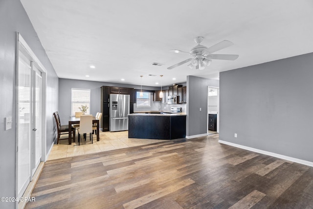 unfurnished living room featuring ceiling fan and light hardwood / wood-style flooring