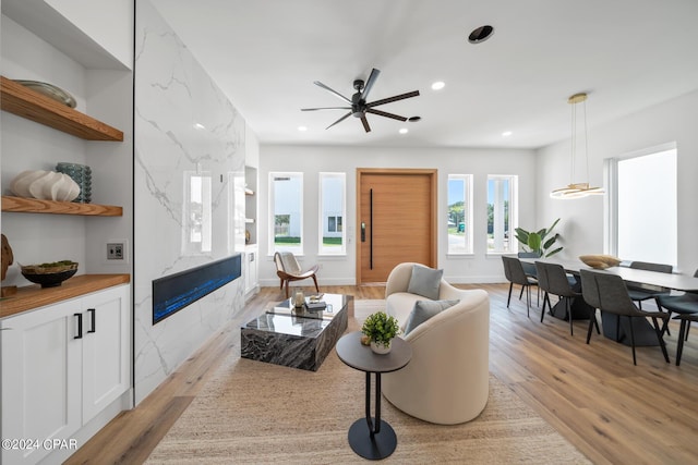 living room featuring light hardwood / wood-style flooring and ceiling fan