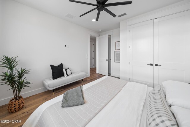 bedroom featuring ceiling fan, a closet, and dark wood-type flooring