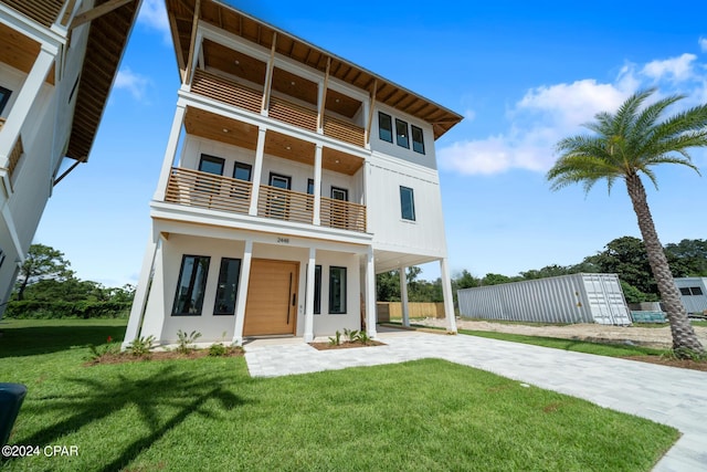 contemporary house with a balcony and a front lawn