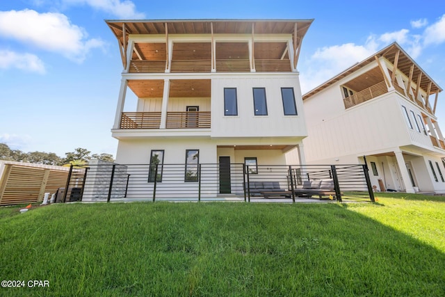 rear view of house with a balcony and a yard