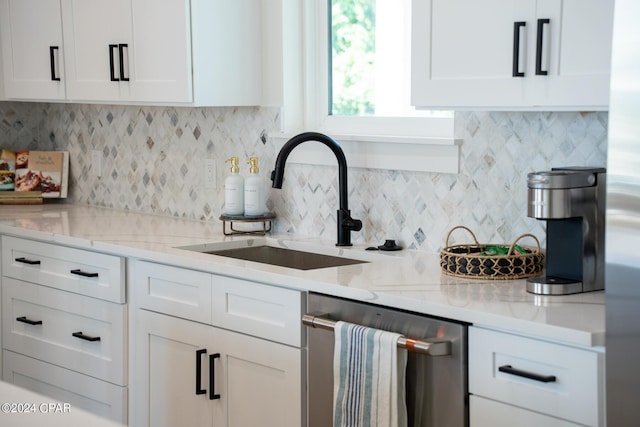 kitchen featuring stainless steel dishwasher, decorative backsplash, white cabinets, and sink