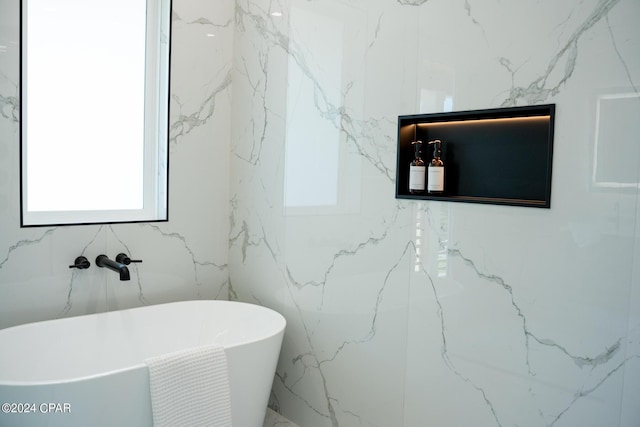 bathroom with a bath and tile walls