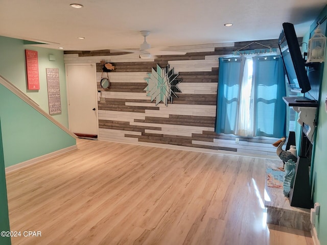 interior space with wooden walls, ceiling fan, and hardwood / wood-style flooring