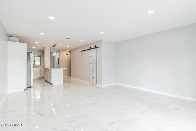 unfurnished living room featuring a barn door