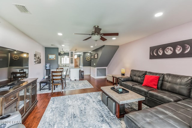 living room featuring ceiling fan and dark wood-type flooring