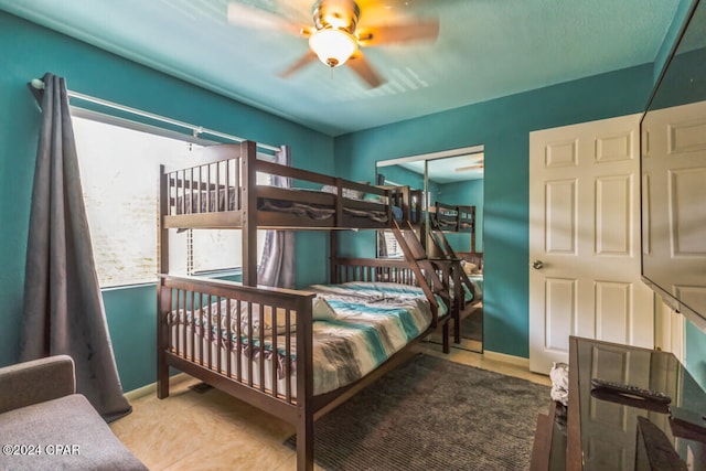 bedroom with tile patterned flooring, ceiling fan, and a closet