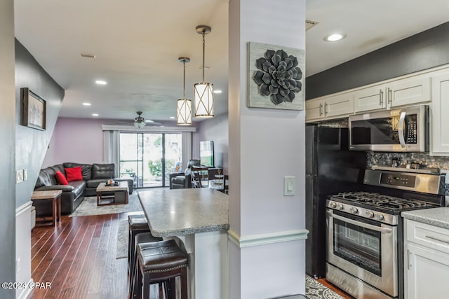 kitchen featuring white cabinetry, ceiling fan, decorative light fixtures, and appliances with stainless steel finishes