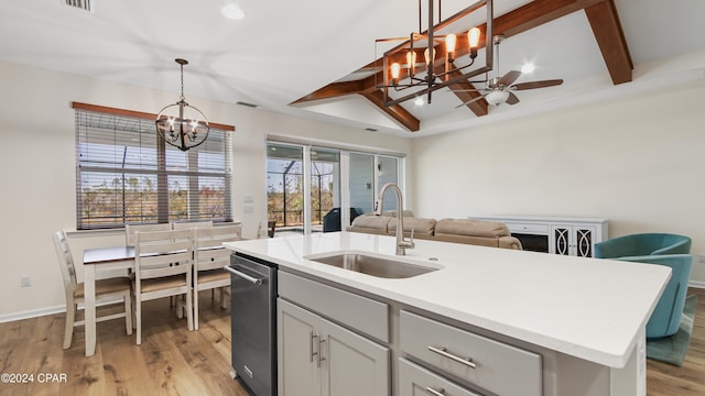 kitchen featuring sink, vaulted ceiling with beams, decorative light fixtures, a center island with sink, and light wood-type flooring