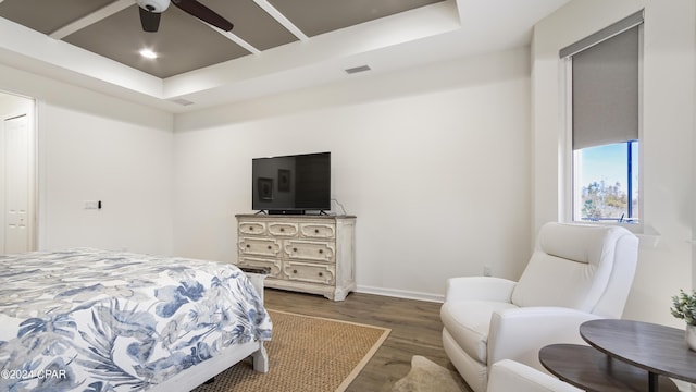 bedroom with dark wood-type flooring, ceiling fan, and a raised ceiling