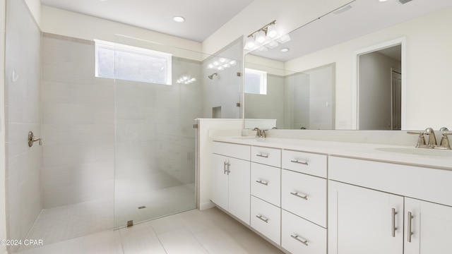 bathroom with tiled shower and vanity