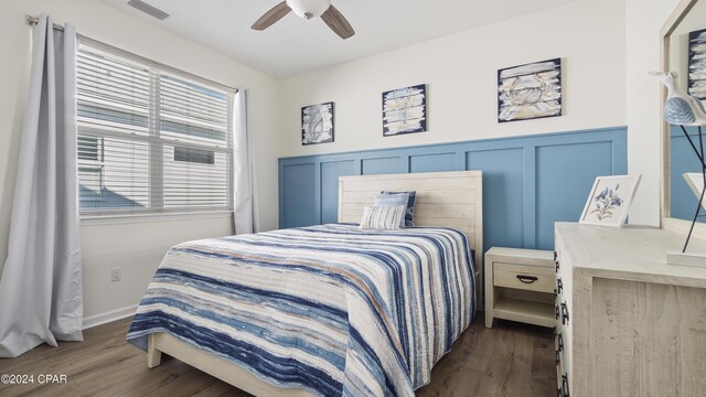 bedroom with dark hardwood / wood-style floors and ceiling fan