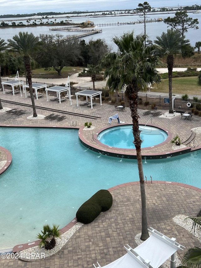 view of pool with a patio and a water view