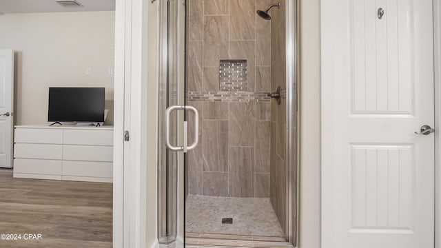 bathroom featuring hardwood / wood-style floors and an enclosed shower