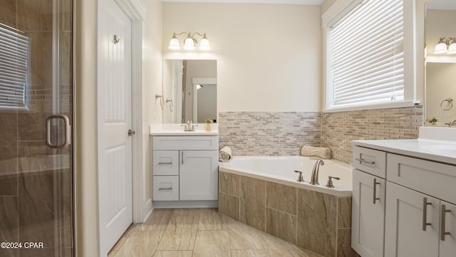 bathroom with vanity and shower with separate bathtub