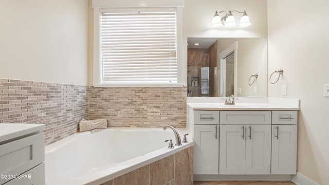 bathroom with vanity and tiled bath