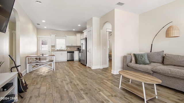 living room featuring sink and light hardwood / wood-style floors