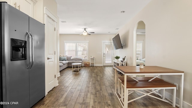 interior space with ceiling fan, white cabinets, dark wood-type flooring, and stainless steel refrigerator with ice dispenser