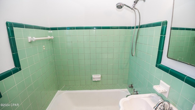 bathroom featuring tiled shower / bath and tile walls