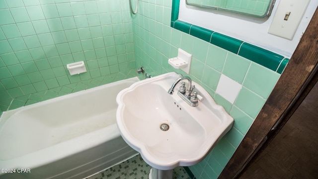 bathroom with sink and tile walls