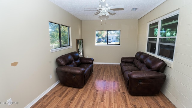 sitting room with hardwood / wood-style floors, a textured ceiling, and ceiling fan