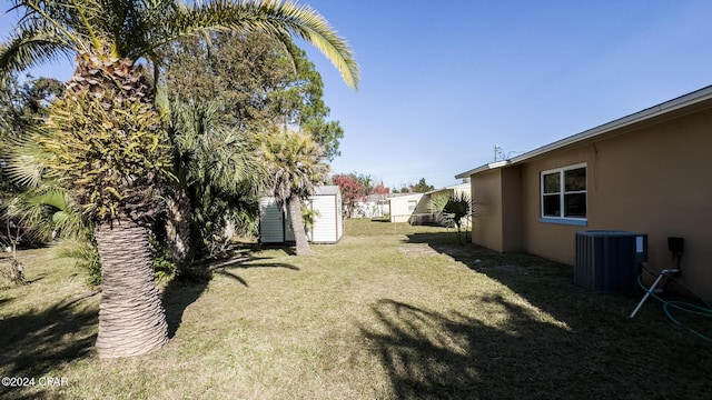 view of yard with central AC and a storage shed