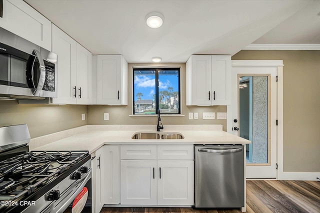 kitchen featuring white cabinetry, sink, dark hardwood / wood-style flooring, crown molding, and appliances with stainless steel finishes