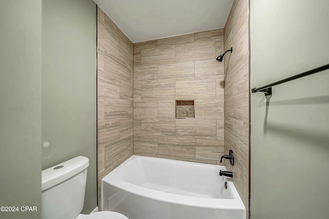 bathroom with toilet and tiled shower / bath