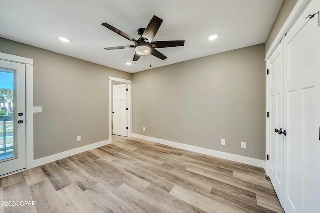 unfurnished bedroom featuring access to exterior, ceiling fan, and light hardwood / wood-style flooring