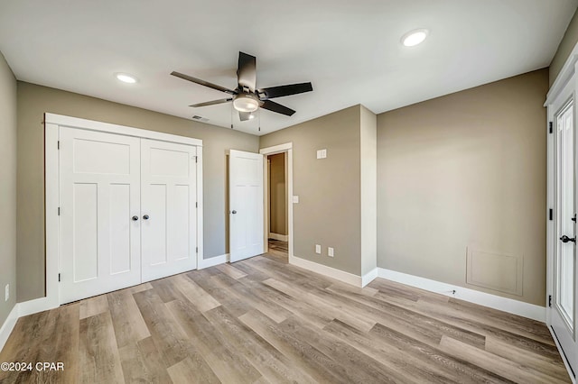 unfurnished bedroom with ceiling fan, a closet, and light hardwood / wood-style floors