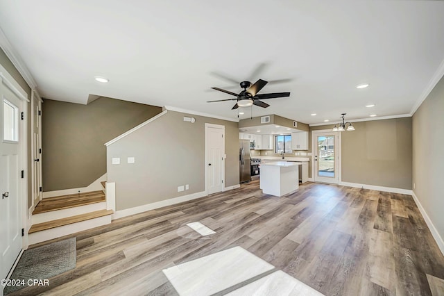 unfurnished living room featuring crown molding, light hardwood / wood-style floors, and ceiling fan with notable chandelier