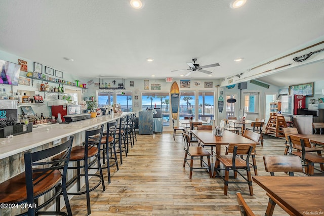 dining space with ceiling fan, a healthy amount of sunlight, light hardwood / wood-style floors, and a textured ceiling