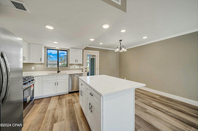 kitchen featuring white cabinetry, stainless steel appliances, pendant lighting, light hardwood / wood-style floors, and a kitchen island