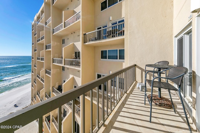 balcony featuring a water view and a beach view