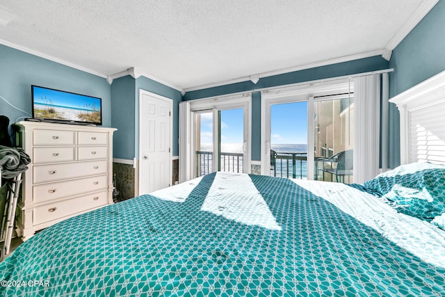 bedroom with a textured ceiling, crown molding, and access to outside