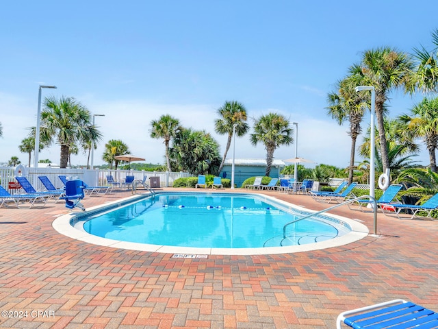 community pool featuring a patio area and fence