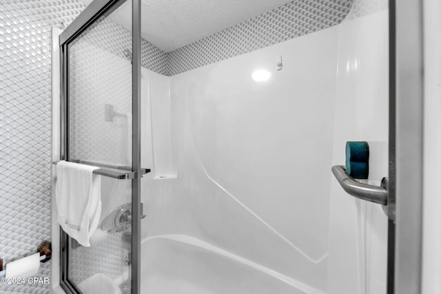 bathroom featuring a stall shower and a textured ceiling