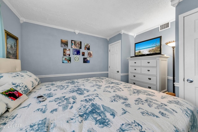 bedroom with a textured ceiling, baseboards, visible vents, and ornamental molding