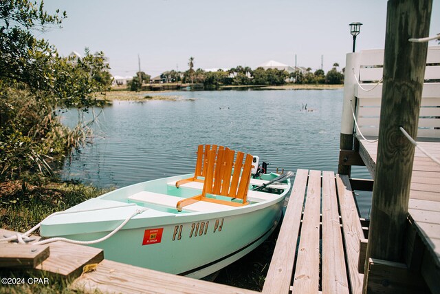 view of pool with a water view, a patio, and a dock