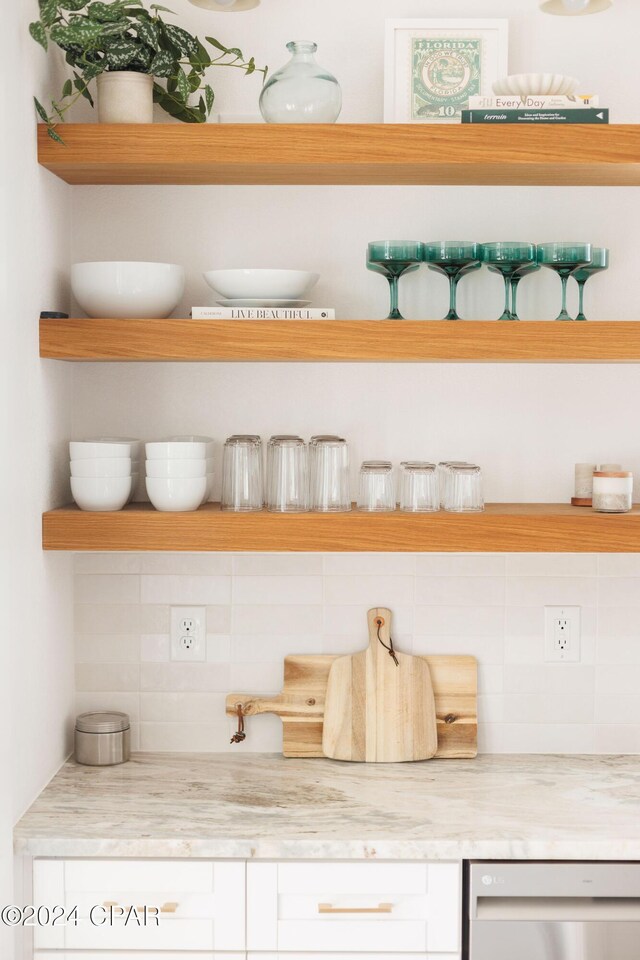 details featuring white cabinets, light stone countertops, and sink