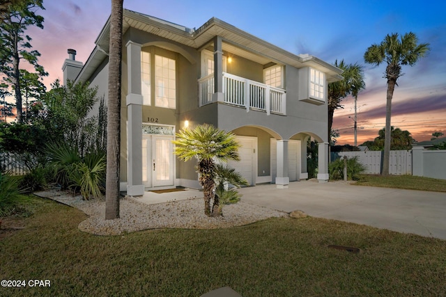 view of front of house featuring a yard and a balcony