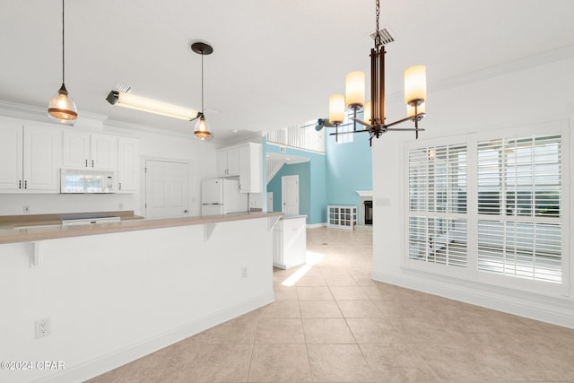 kitchen with pendant lighting, white cabinetry, white appliances, and a breakfast bar area