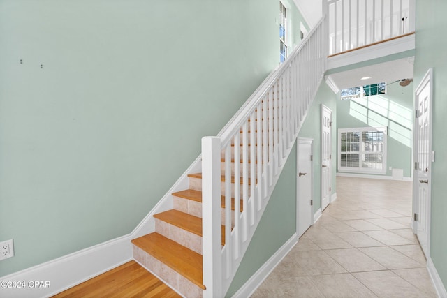 stairs featuring hardwood / wood-style floors and a high ceiling