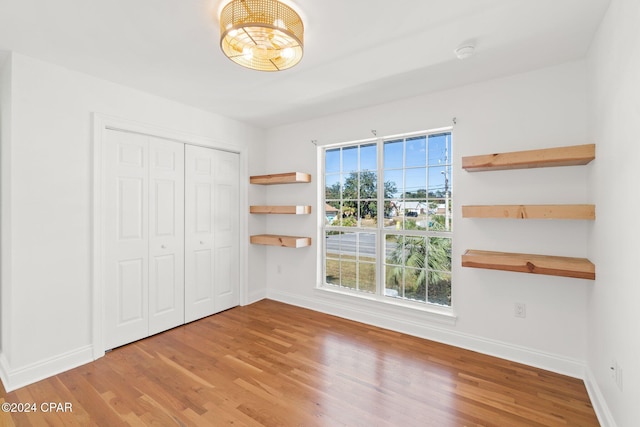 unfurnished bedroom with hardwood / wood-style flooring and a closet